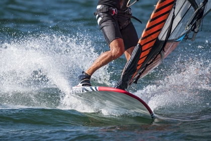 A man windsurfs on bump water